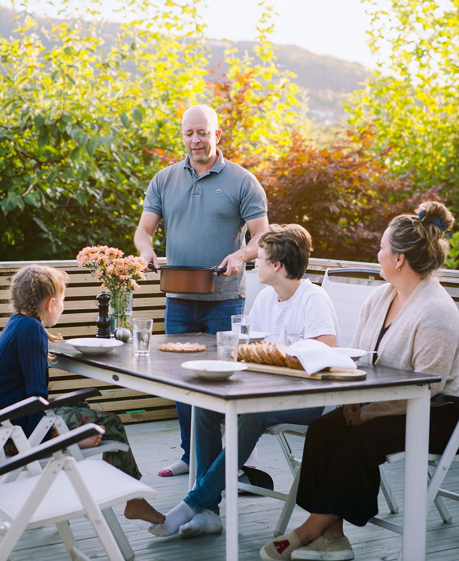 Family eating prawn soup for dinner outside
