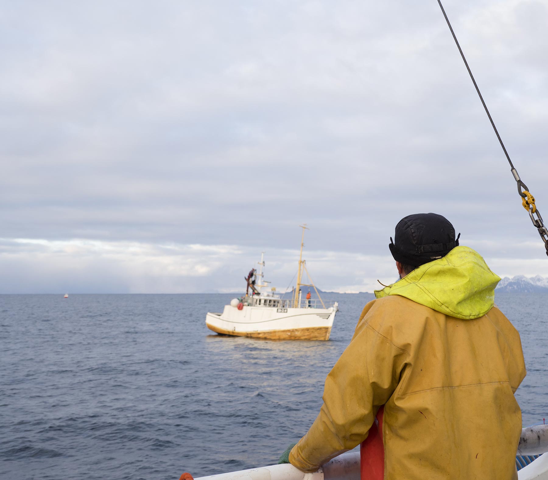 Man looking at fishing boat at sea